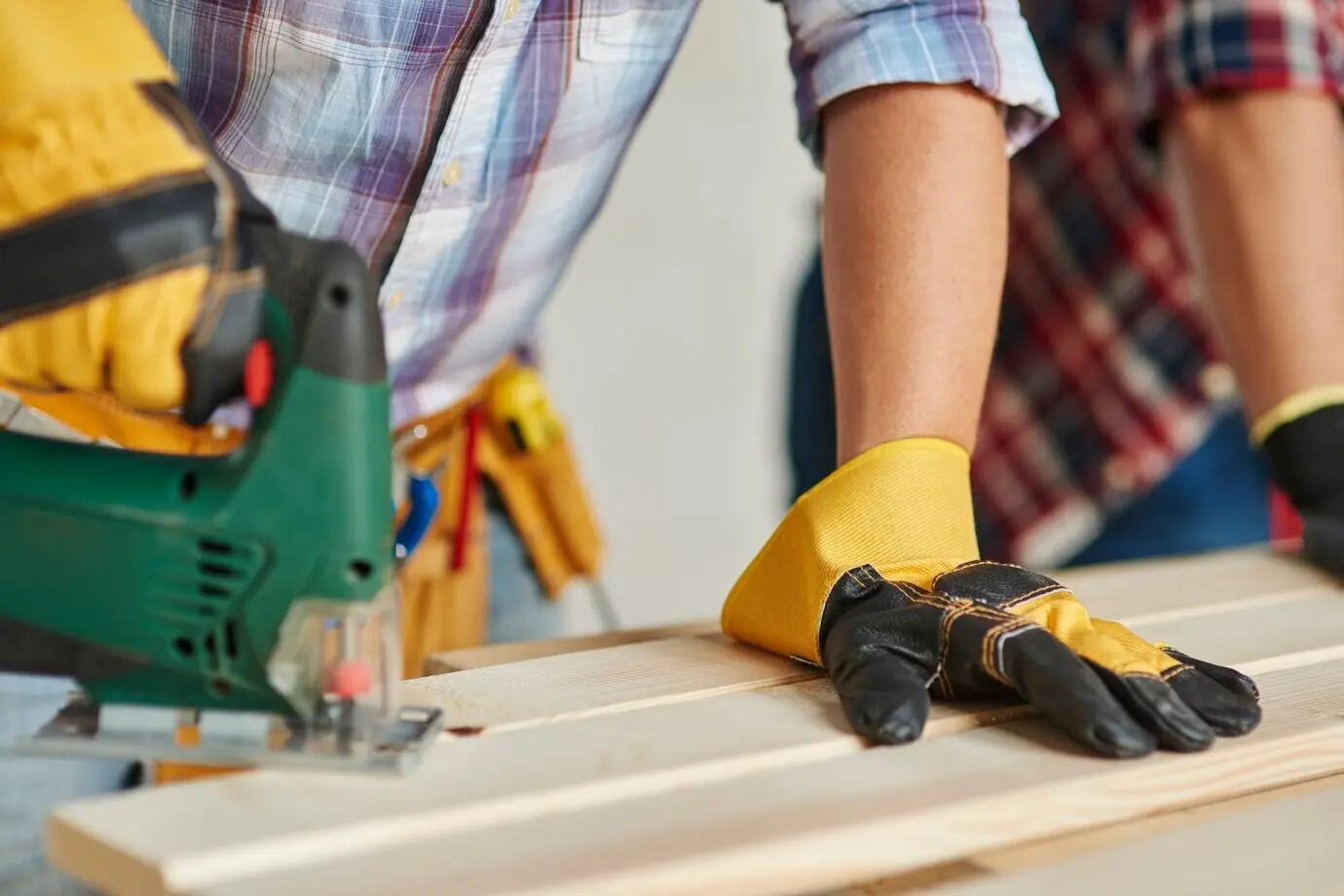 Nahaufnahme eines erfahrenen Schreiners und seines jüngeren Mitarbeiters